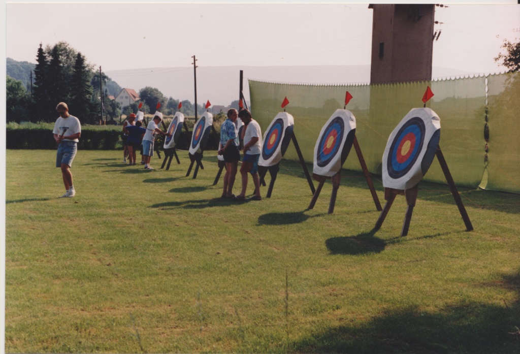 Der Bogenplatz beim Pfingstturnier 1994, wo Scheiben und Bogenschützen und -schützinnen zu sehen sind.