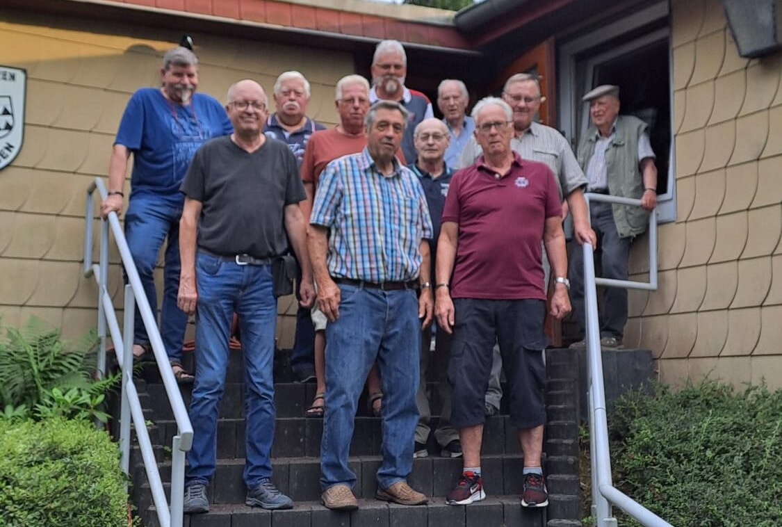 Mehrere Männer stehen auf einer Treppe vor dem Vereinshaus des KKS Eime-Dunsen und posieren für ein Foto.