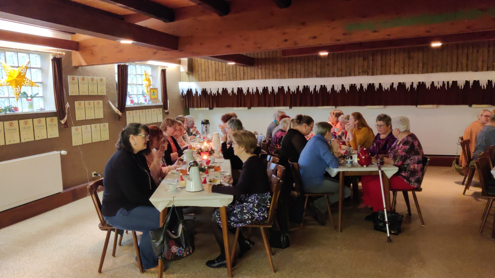 Viele Frauen sitzen an verschiedenen Tischen und Essen und unterhalten sich