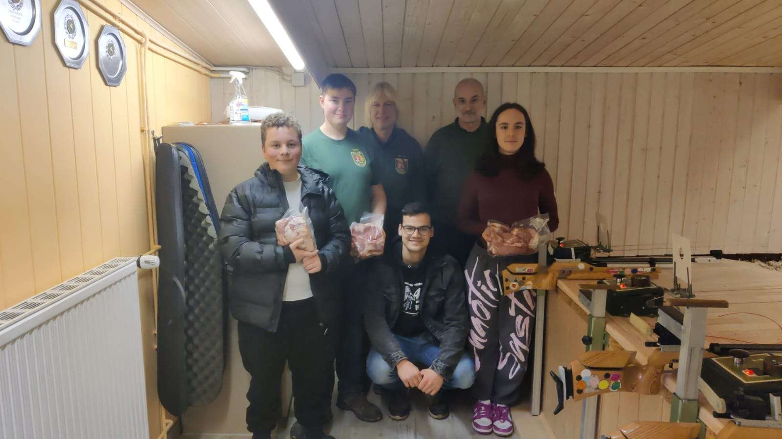 Das Bild zeigt ein Gruppenbild von Jugendlichen und Erwachsenen. Sie halten Fleischpreise in der Hand. Insgesamt sind sechs Personen zu sehen.